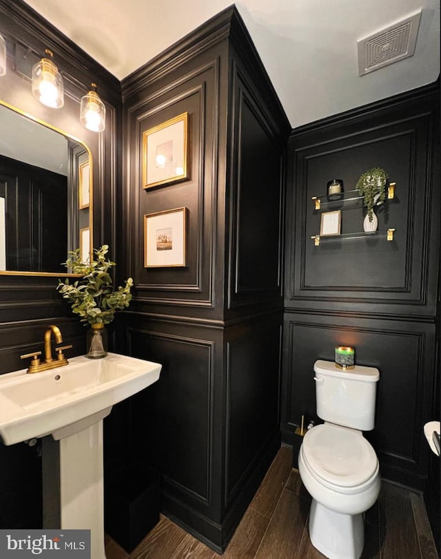 bathroom featuring hardwood / wood-style flooring and toilet