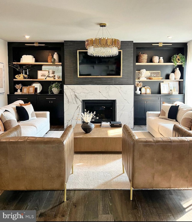 living room featuring hardwood / wood-style floors, built in shelves, and a premium fireplace