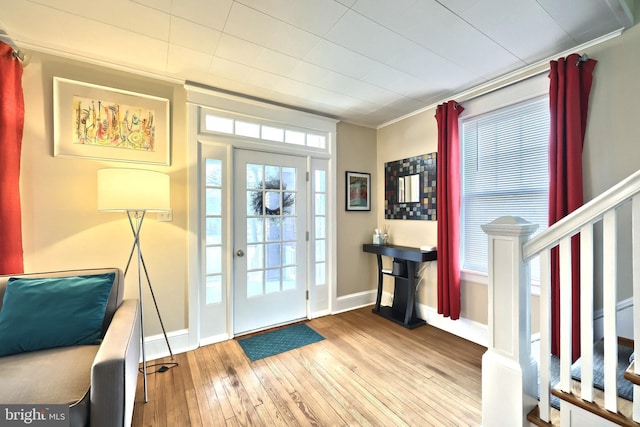 foyer entrance with ornamental molding and light hardwood / wood-style flooring