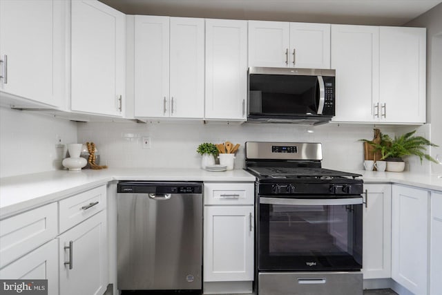 kitchen featuring stainless steel appliances, tasteful backsplash, and white cabinets