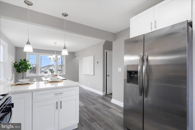 kitchen with white cabinetry, hanging light fixtures, stainless steel fridge, dark hardwood / wood-style flooring, and black gas range