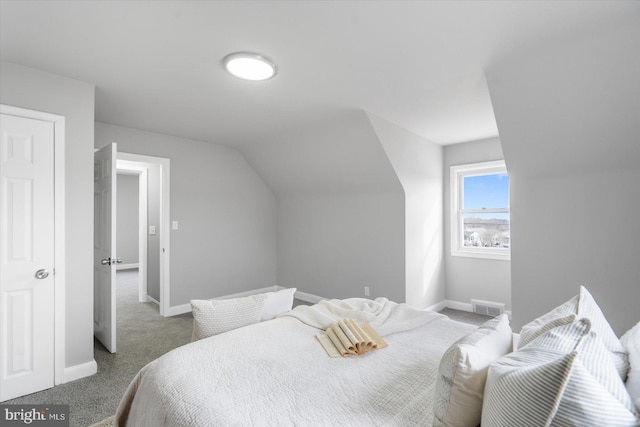 carpeted bedroom with lofted ceiling