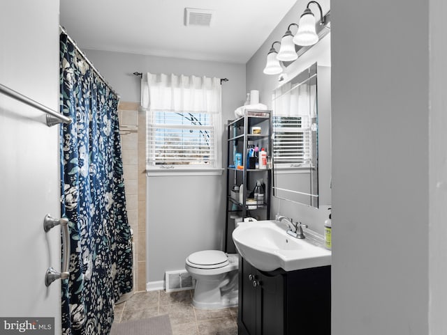 bathroom with walk in shower, vanity, and toilet