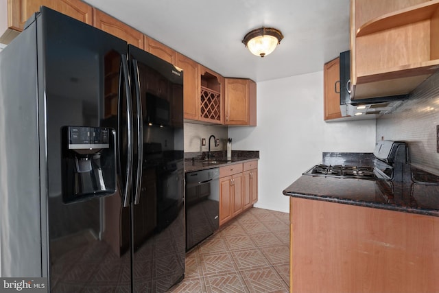 kitchen featuring tasteful backsplash, sink, dark stone countertops, and black appliances