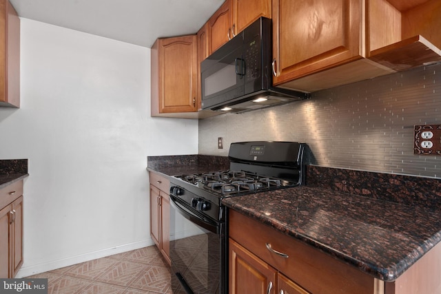 kitchen with dark stone countertops, backsplash, and black appliances