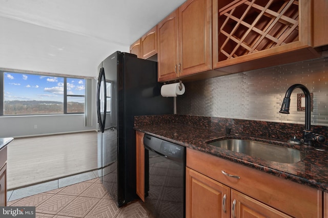 kitchen featuring light tile patterned flooring, sink, dark stone countertops, dishwasher, and backsplash