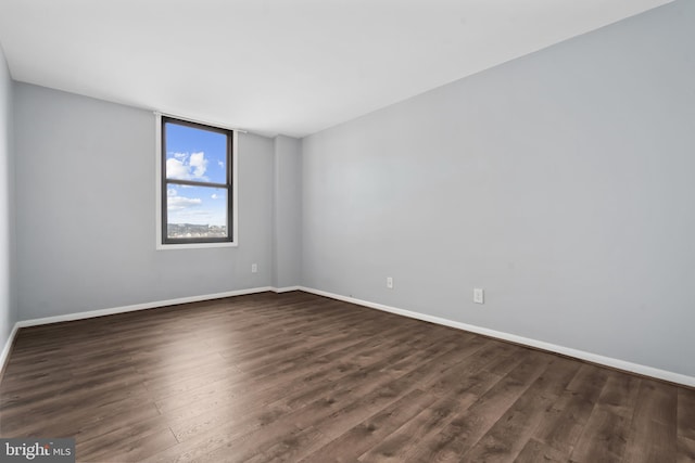 unfurnished room with dark wood-type flooring