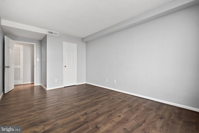 spare room featuring dark wood-type flooring