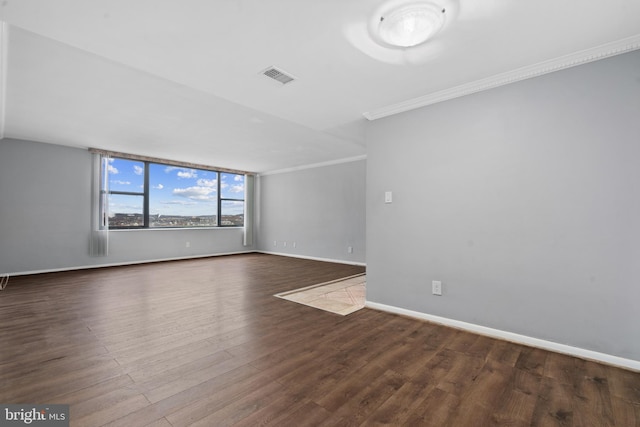 spare room with ornamental molding and dark hardwood / wood-style floors