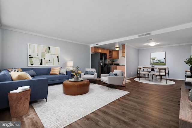 living room with dark hardwood / wood-style flooring and ornamental molding