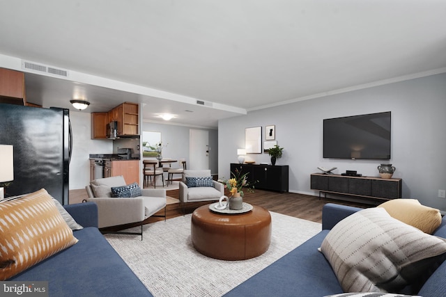 living room featuring ornamental molding and dark hardwood / wood-style floors