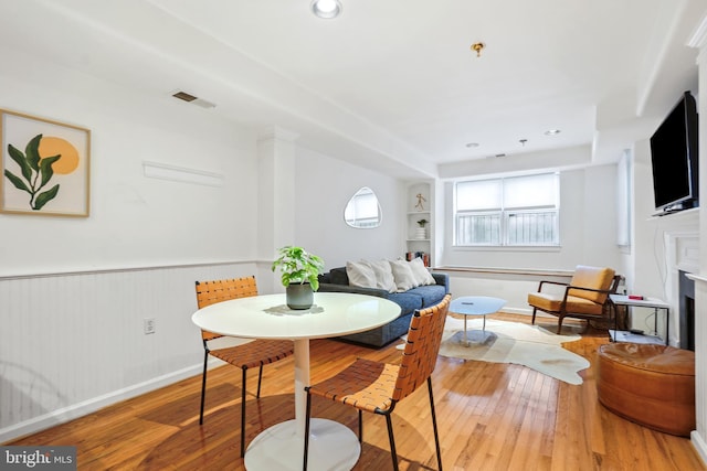 dining space featuring hardwood / wood-style flooring and built in shelves