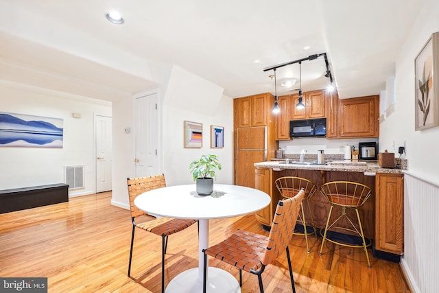 dining room featuring track lighting and light hardwood / wood-style floors