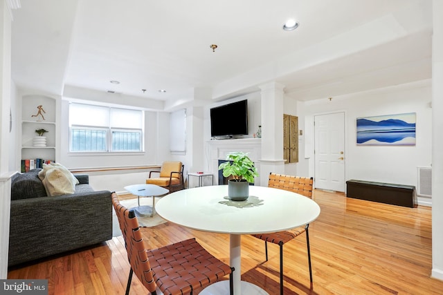 dining area with built in shelves and light wood-type flooring