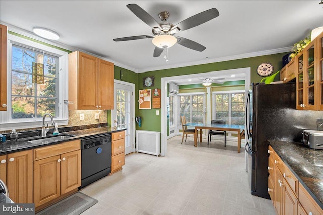 kitchen with sink, crown molding, black appliances, dark stone countertops, and backsplash