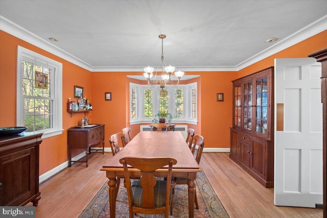 dining space with ornamental molding, a healthy amount of sunlight, and light hardwood / wood-style floors