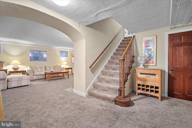 stairs featuring carpet flooring and a textured ceiling