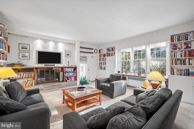 living room with radiator heating unit and light colored carpet