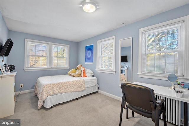 bedroom featuring radiator heating unit and light carpet