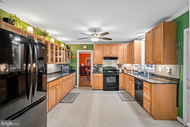 kitchen featuring sink, crown molding, black appliances, dark stone countertops, and backsplash