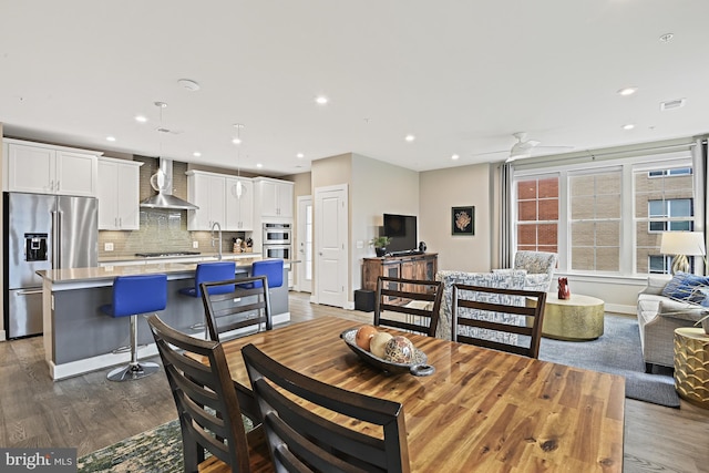 dining area with dark wood-type flooring, sink, and ceiling fan