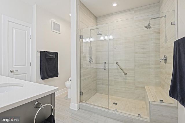 bathroom featuring vanity, toilet, and an enclosed shower