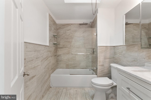 full bath with toilet, washtub / shower combination, tile walls, and vanity