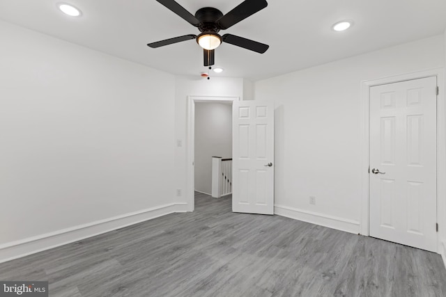 spare room featuring a ceiling fan, recessed lighting, light wood-style flooring, and baseboards