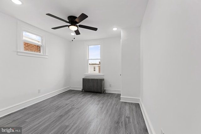 unfurnished room with recessed lighting, a ceiling fan, baseboards, radiator, and dark wood-style floors