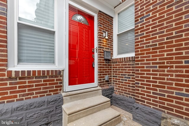 doorway to property with brick siding