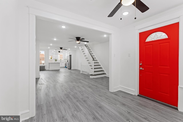 entrance foyer with recessed lighting, wood finished floors, baseboards, and stairs