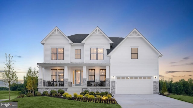 modern farmhouse with a garage, a yard, and covered porch