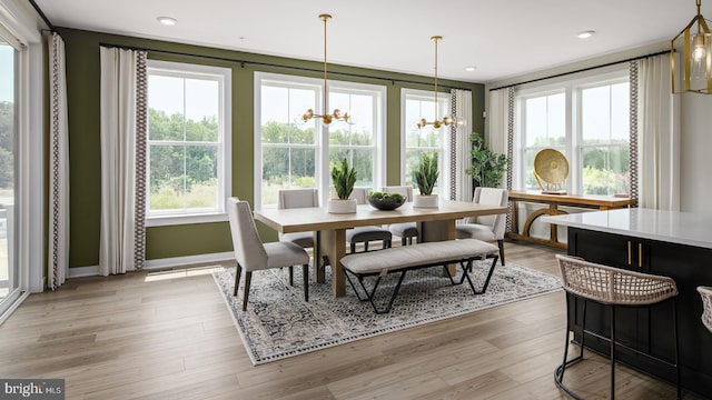 dining space with light hardwood / wood-style floors and a notable chandelier