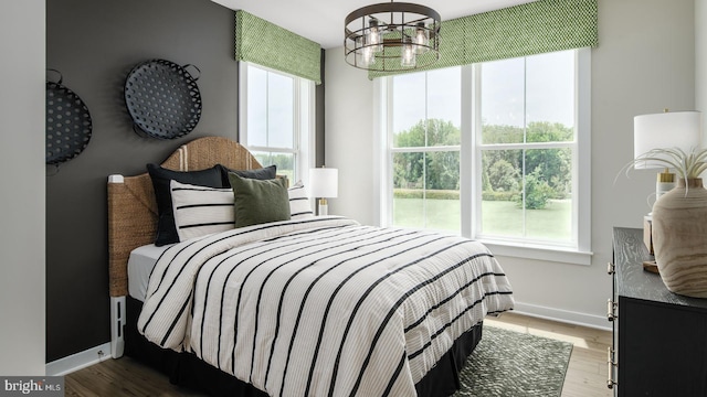 bedroom with wood-type flooring and a chandelier