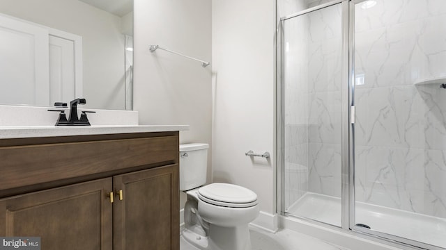 bathroom with vanity, toilet, and a shower with shower door