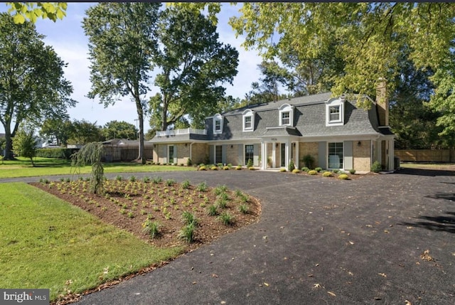 cape cod house featuring a front yard