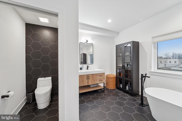 bathroom featuring toilet, vanity, a bath, and tile patterned flooring