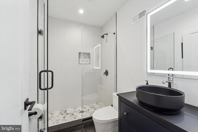 bathroom with walk in shower, vanity, and toilet