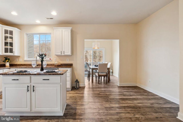 kitchen with white cabinetry, a healthy amount of sunlight, dark hardwood / wood-style flooring, and decorative light fixtures