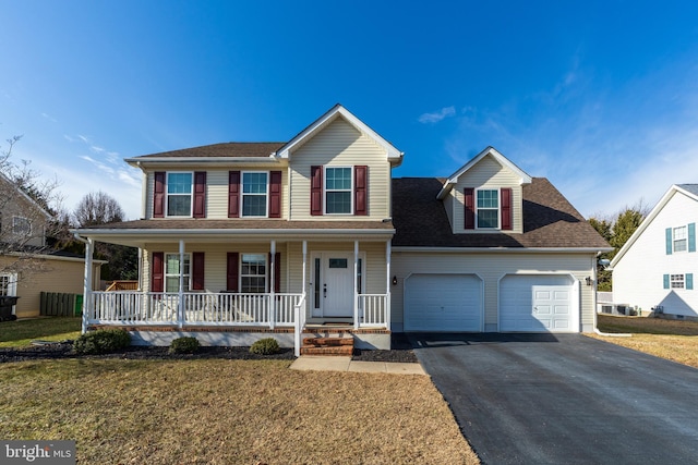 view of front of property featuring a garage, a front lawn, and a porch