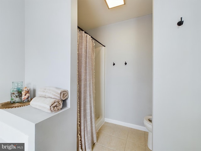 bathroom with a shower with curtain, tile patterned floors, and toilet