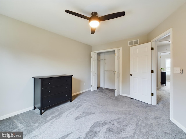 unfurnished bedroom with light colored carpet, ceiling fan, and a closet