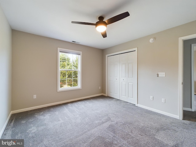 unfurnished bedroom featuring carpet floors, a closet, and ceiling fan