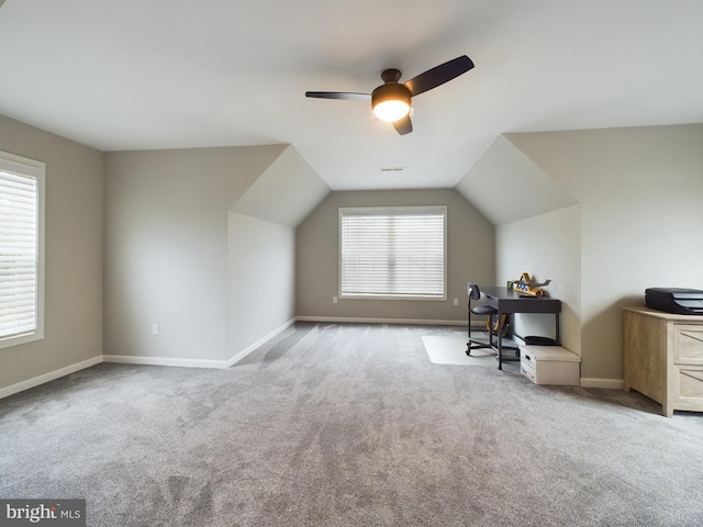 unfurnished office with ceiling fan, light colored carpet, and vaulted ceiling