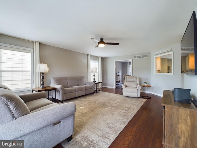 living room featuring dark hardwood / wood-style floors and ceiling fan