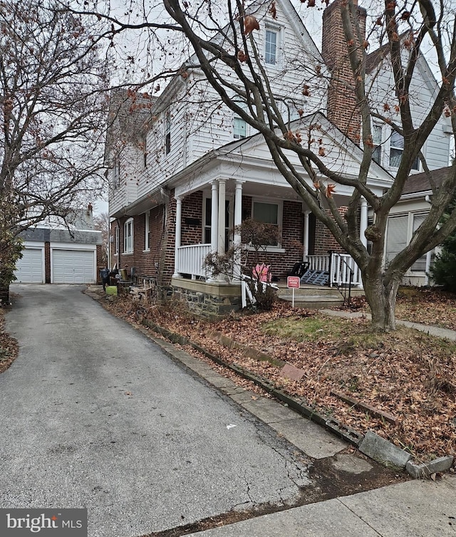 view of front facade featuring an outbuilding, a garage, and covered porch