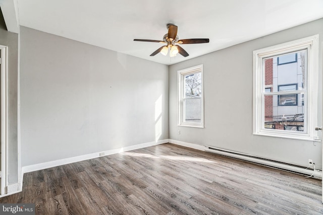 spare room featuring dark hardwood / wood-style flooring, ceiling fan, and baseboard heating