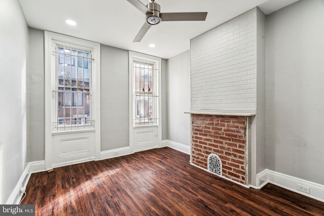 unfurnished living room with ceiling fan, a fireplace, and dark hardwood / wood-style flooring