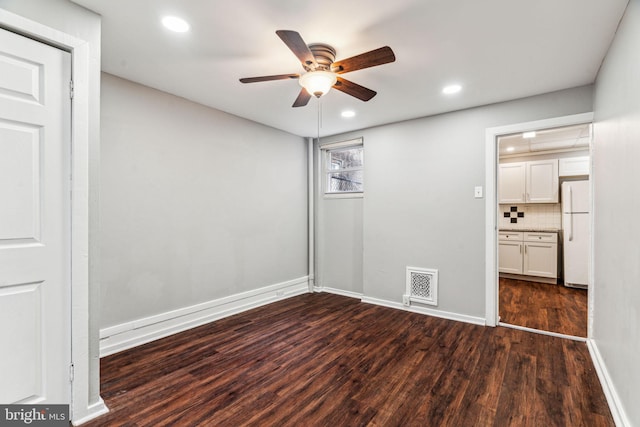 unfurnished room featuring dark wood-type flooring and ceiling fan