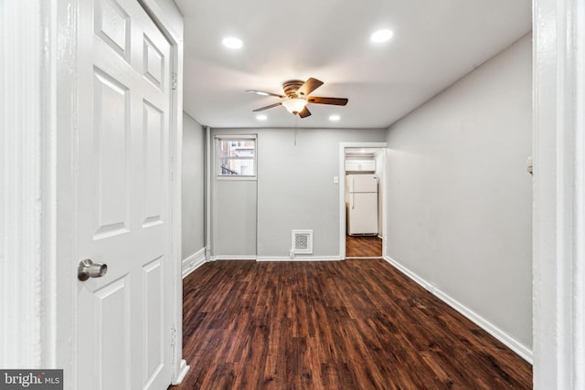 empty room with ceiling fan and dark hardwood / wood-style flooring